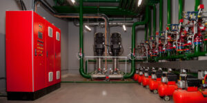 Industrial interior of water pump, valves, pressure gauges, motors inside engine room. Valve and pumps in an industrial room. Urban modern powerful pipelines and pumps, automatic control systems